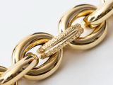 a close up of a gold chain on a white surface