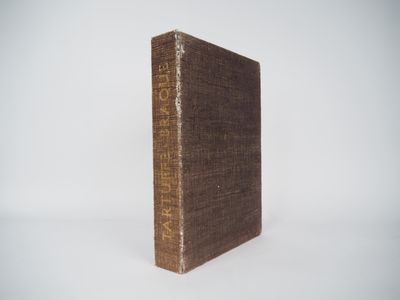 an old book sitting on top of a white table next to a white wall