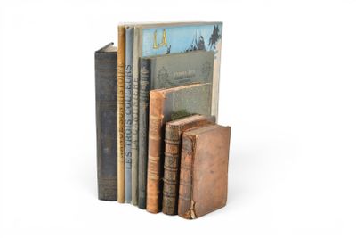 plusieurs vieux livres sont empilés sur une surface blanche