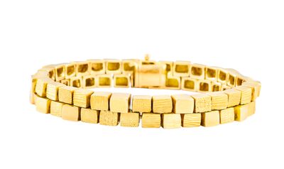 gros plan d'un bracelet en or sur fond blanc