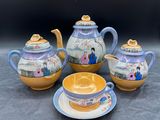 trois théières et une tasse posées sur une table