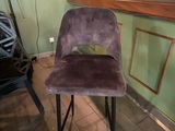 une chaise violette posée devant un bar
