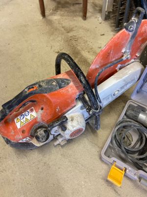 two chainsaws sitting on the floor next to a tool box
