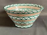 a green and white bowl sitting on a table