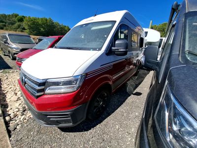 une camionnette rouge et blanche garée sur un parking