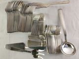 many forks and spoons on a table with a spoon and spoon rest