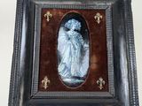 une vieille photo d'une femme en robe bleue, dans un cadre noir