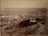 une vieille photo montrant une vue d'une ville depuis le sommet d'une colline