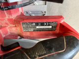 a close up of a red corded drill with a black handle
