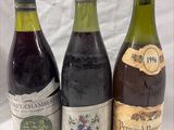 three bottles of wine are lined up on a white surface