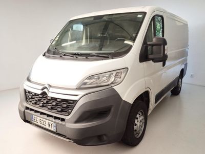 La camionnette blanche est garée dans une pièce blanche au sol blanc.