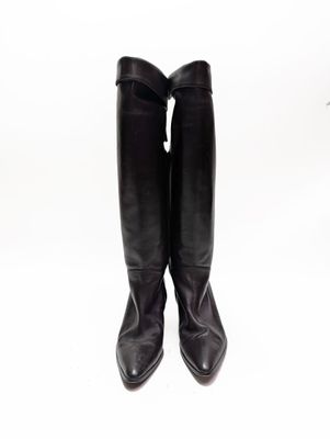 une paire de bottes en cuir noir sur fond blanc