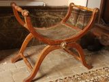 a wooden bench with a woven seat in a room