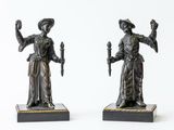 pair of antique bronze figurines of a woman holding a torch and a candle
