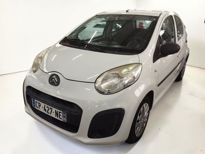 une petite voiture blanche garée dans une pièce