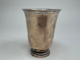 a silver vase that is sitting on a table