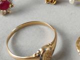 a gold ring and a pair of earrings on a table