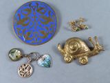 une broche bleue et dorée ainsi que d'autres bijoux posés sur une table