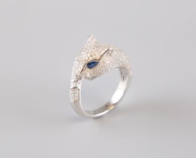 un gros plan d'une bague en argent ornée d'une pierre bleue au centre