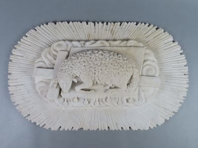 a white sculpture of a sheep and a bird on the wall