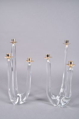 trois bougeoirs en verre transparent surmontés de bougeoirs dorés