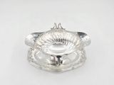 an antique silver plate with a flower shaped bowl on it