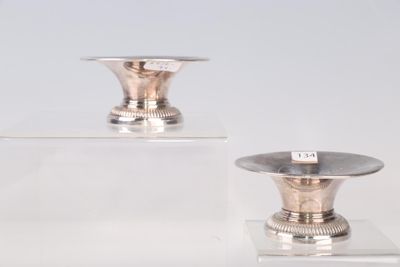 deux vases en argent posés sur une étagère transparente