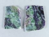 deux morceaux de marbre vert et violet posés sur une surface blanche