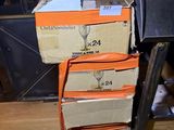 several boxes of wine glasses stacked on top of each other on a wooden floor