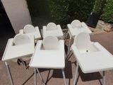quatre chaises hautes blanches et une chaise haute pour bébé au milieu d'une allée