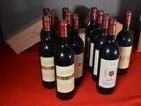 six bottles of red wine are lined up on a table