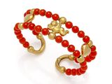 un gros plan sur un bracelet en perles rouges rehaussé de touches dorées