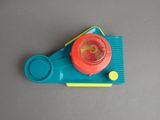 a small plastic object with a red light on top of it