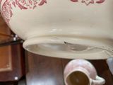 a white bowl with red designs on it sitting on a table