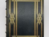 an old black book with gold trimming and a gold border