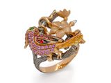 un gros plan d'une bague ornée d'un oiseau et de fleurs