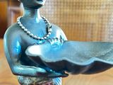 a figurine of a woman holding a tray on a table