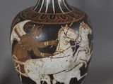 a black and white vase with a picture of a man riding a horse