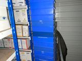 a blue shelf with boxes on it in a storage room