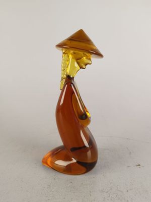 une image représentant une figurine en verre représentant une personne portant un chapeau