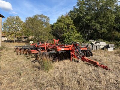 a red plow in the middle of a field