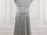 grey and white dress on a mannequin stand in front of a white wall