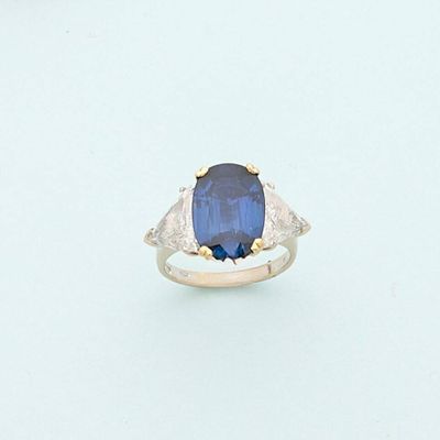 a blue sapphire and diamond ring on a white surface