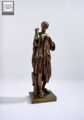 statue en bronze d'une femme tenant un oiseau sur un piédestal