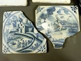 several pieces of blue and white tile sitting on top of a table