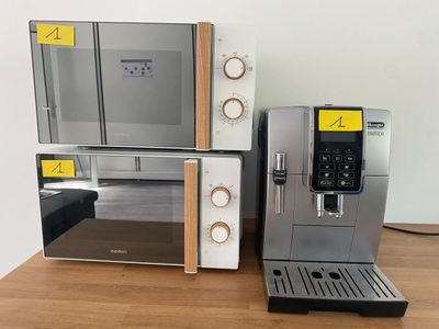 une machine à café posée sur une table à côté d'un micro-ondes