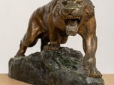 an image of a bronze statue of a lion on a rock