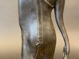 statue of a person in a seated position on a gray surface