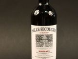 a bottle of red wine sitting on top of a black table