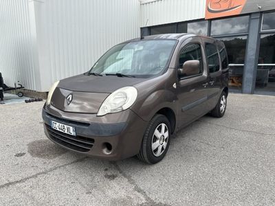 La camionnette marron est garée devant un immeuble.